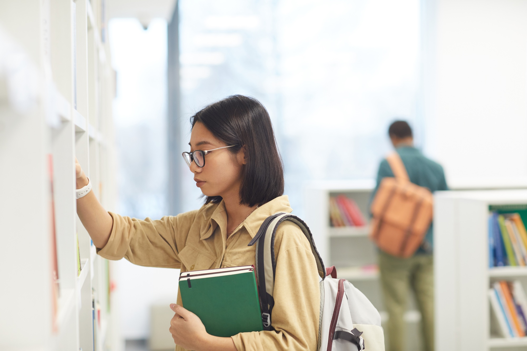 Asian Student Choosing Books in Library